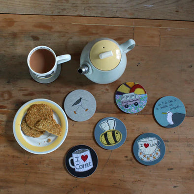 Display of Poppy Treffry coasters and mugs. With pot of tea and biscuits to celebrate national tea day.