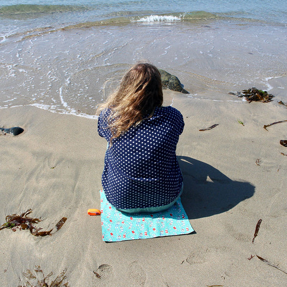 woman sitting on bathers mini dry mat